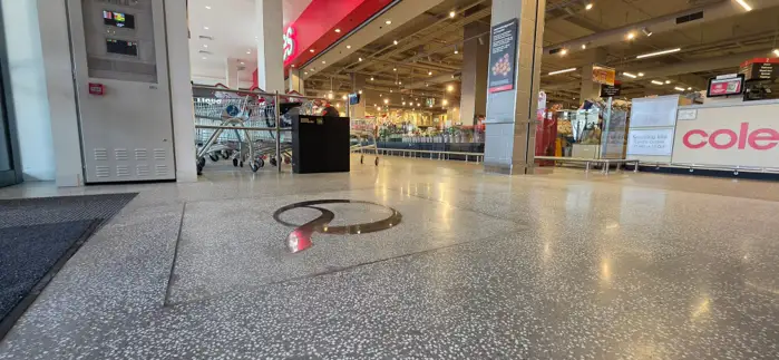 Polished terrazzo floor with a brass inlay detail at Coles Caringbah
