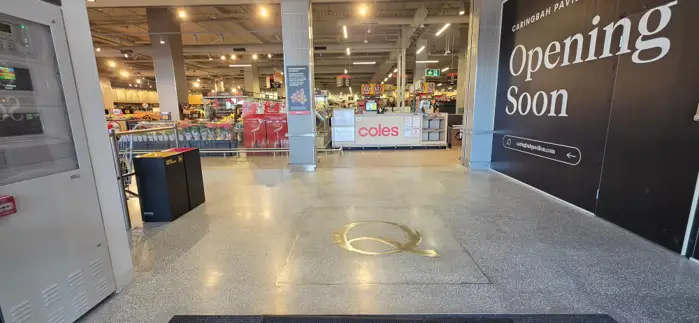 Polished terrazzo floor with a brass ring inlay at the Coles Caringbah entrance