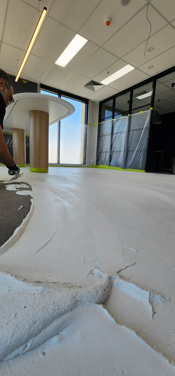 Microcement being hand-trowelled on-site during a Woolooware fit-out