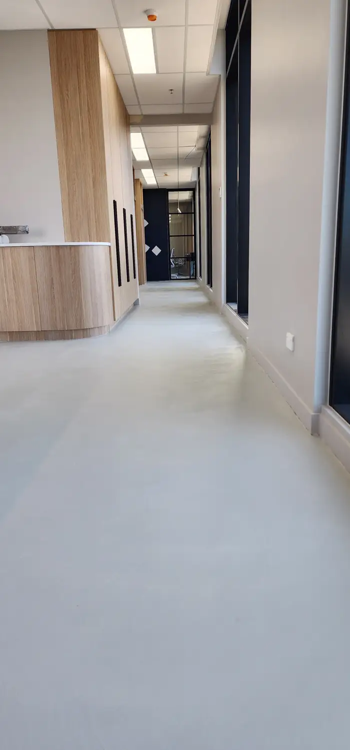 Seamless microcement floor running the length of a Woolooware fit-out