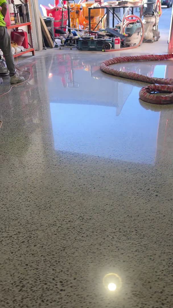 A finished mechanically polished concrete floor — polished exposed aggregate reflecting the space above it